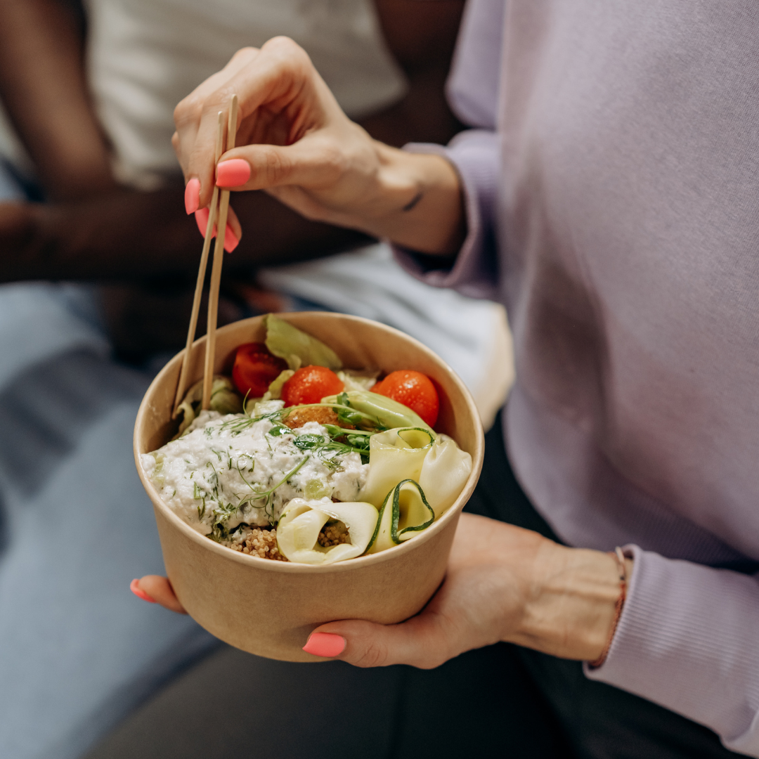 A person holding a bowl of fresh healthy food