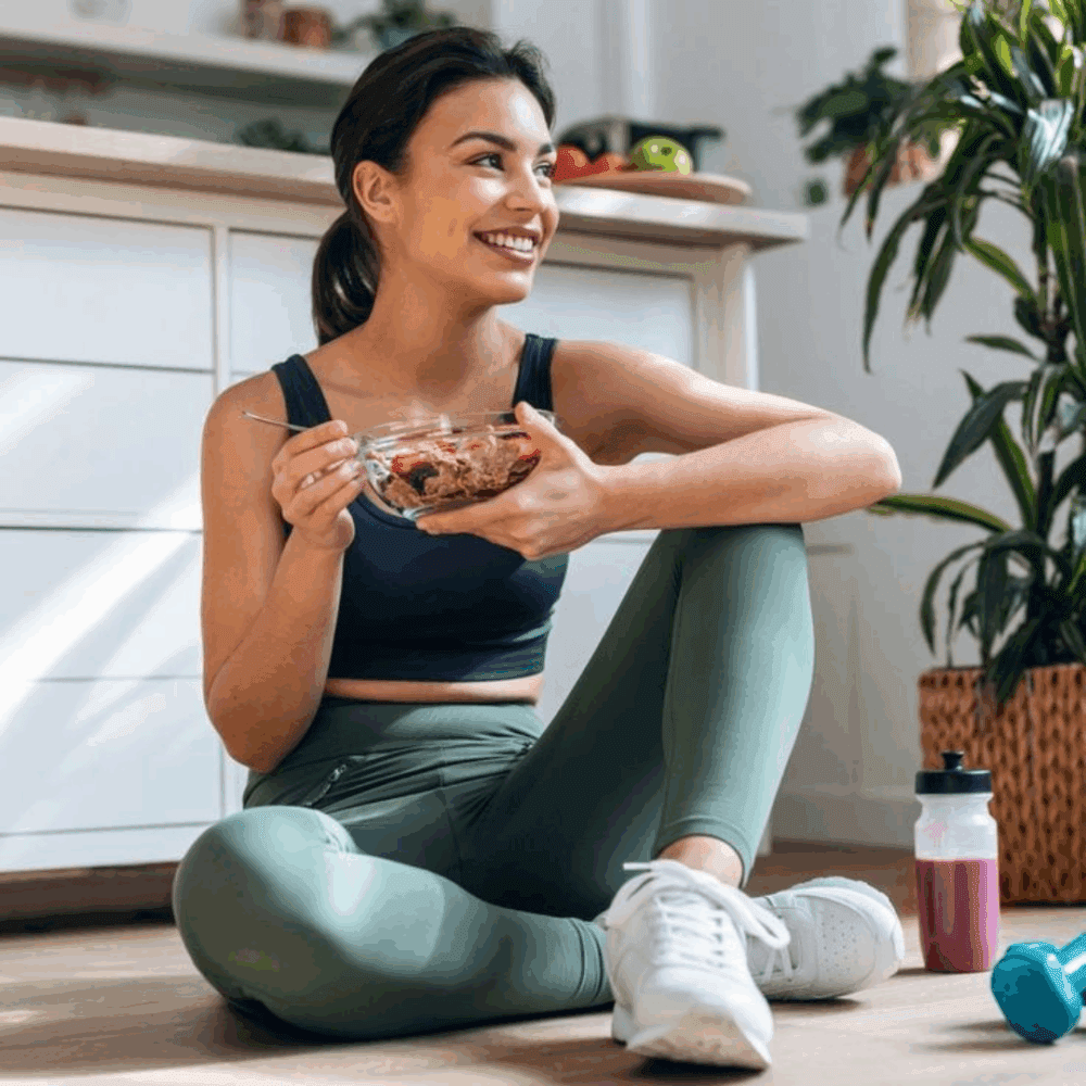 Person relaxing after a workout with a nourishing meal in hand