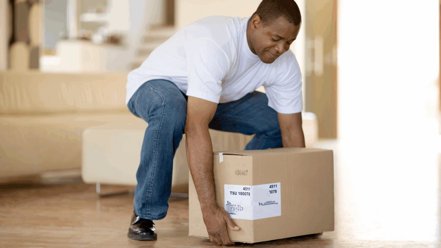 Everyday activity like picking up a heavy box – relatable, showing core strength in daily life.