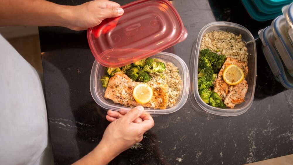 Someone meal-prepping, surrounded by containers.