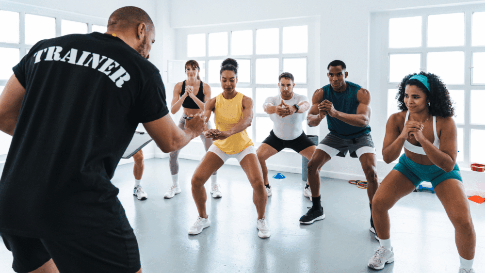 A trainer correcting someone’s squat form.