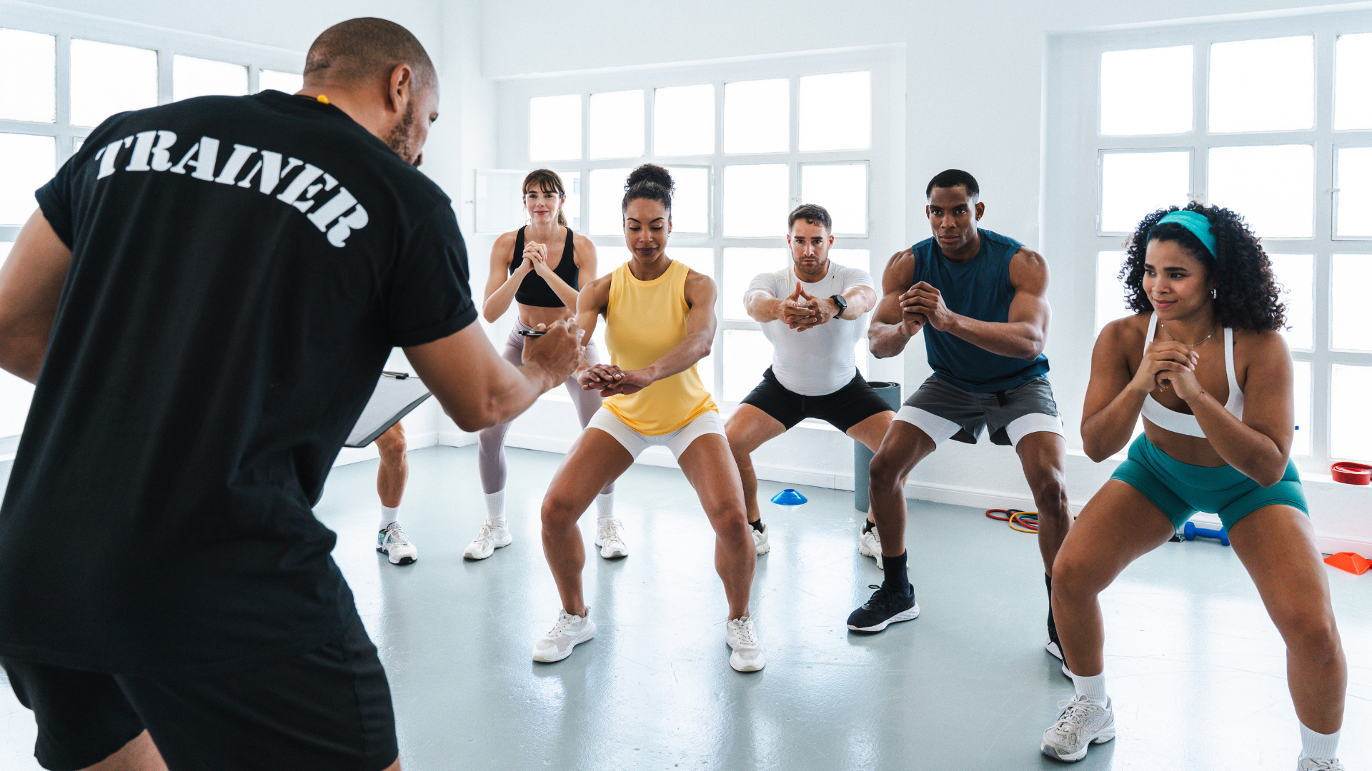 A trainer correcting someone’s squat form.