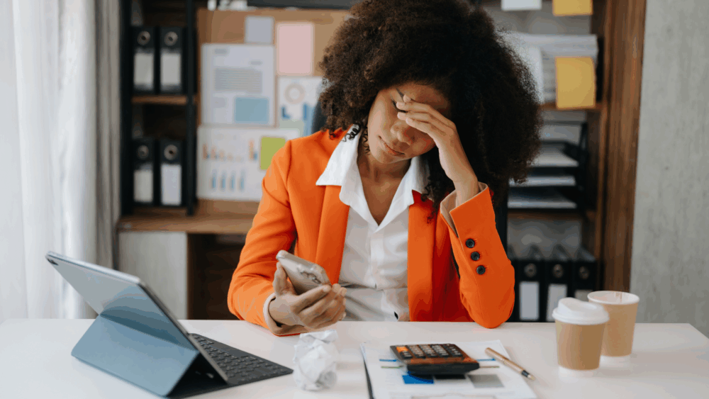 Person holding their head in frustration while sitting on a couch or at a desk – symbolizing stress + feeling stuck in healing.