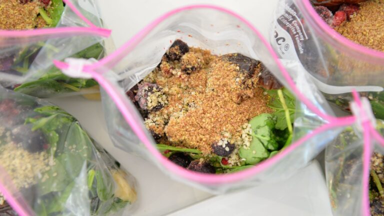 Smoothie prep packs in zip bags (berries, spinach, bananas) ready for blending.