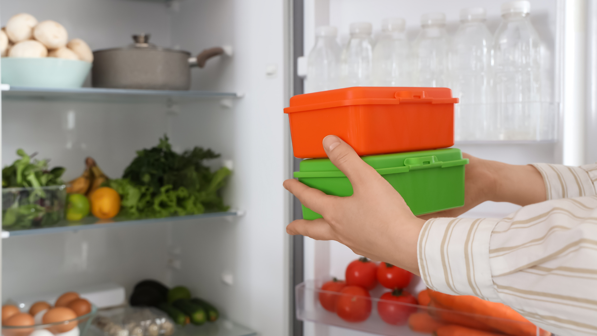 A busy professional taking a prepped meal from the fridge before work.