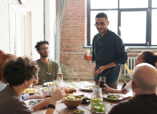 A diverse group of employees enjoying a healthy lunch together in a workplace break area.