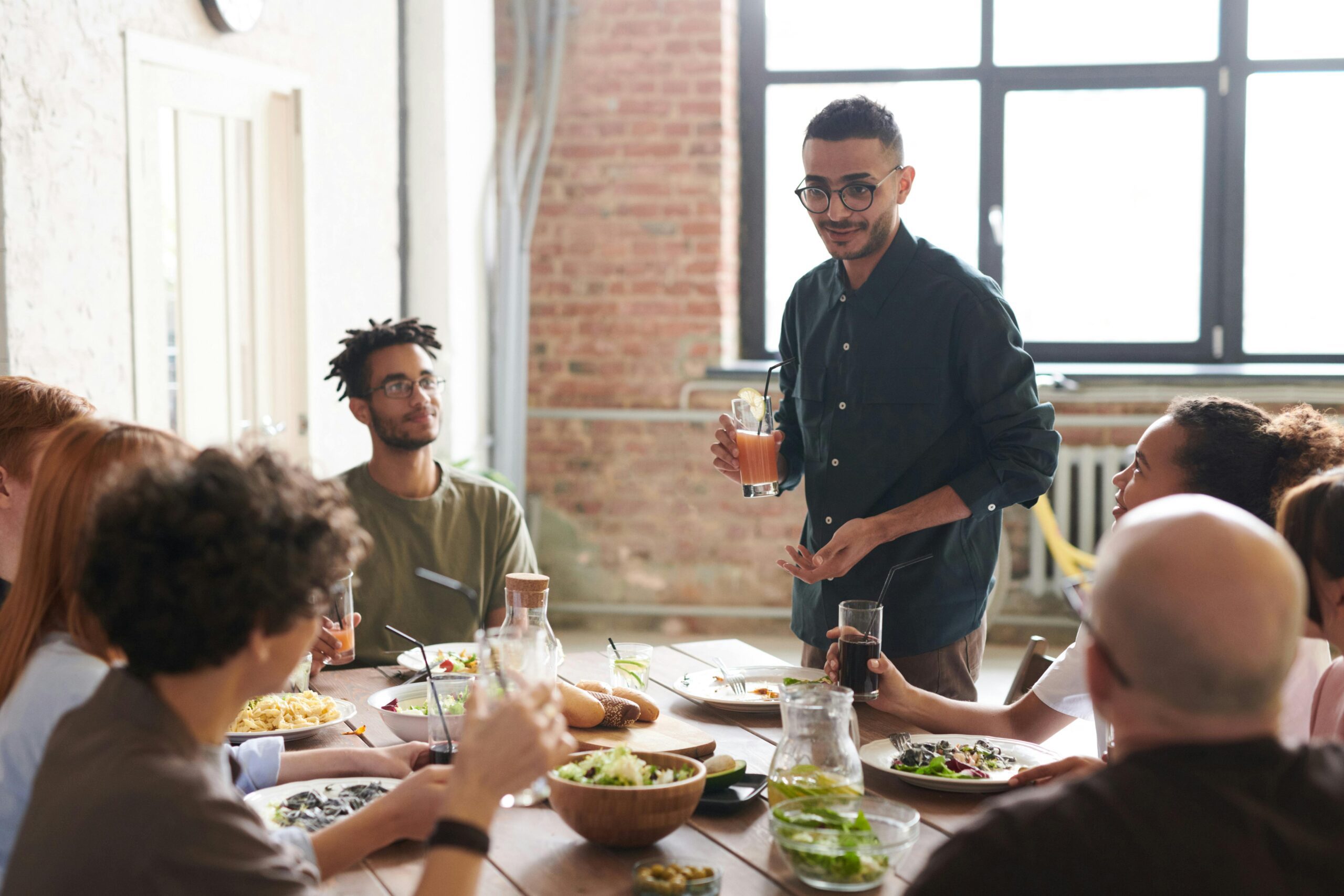 A diverse group of employees enjoying a healthy lunch together in a workplace break area.